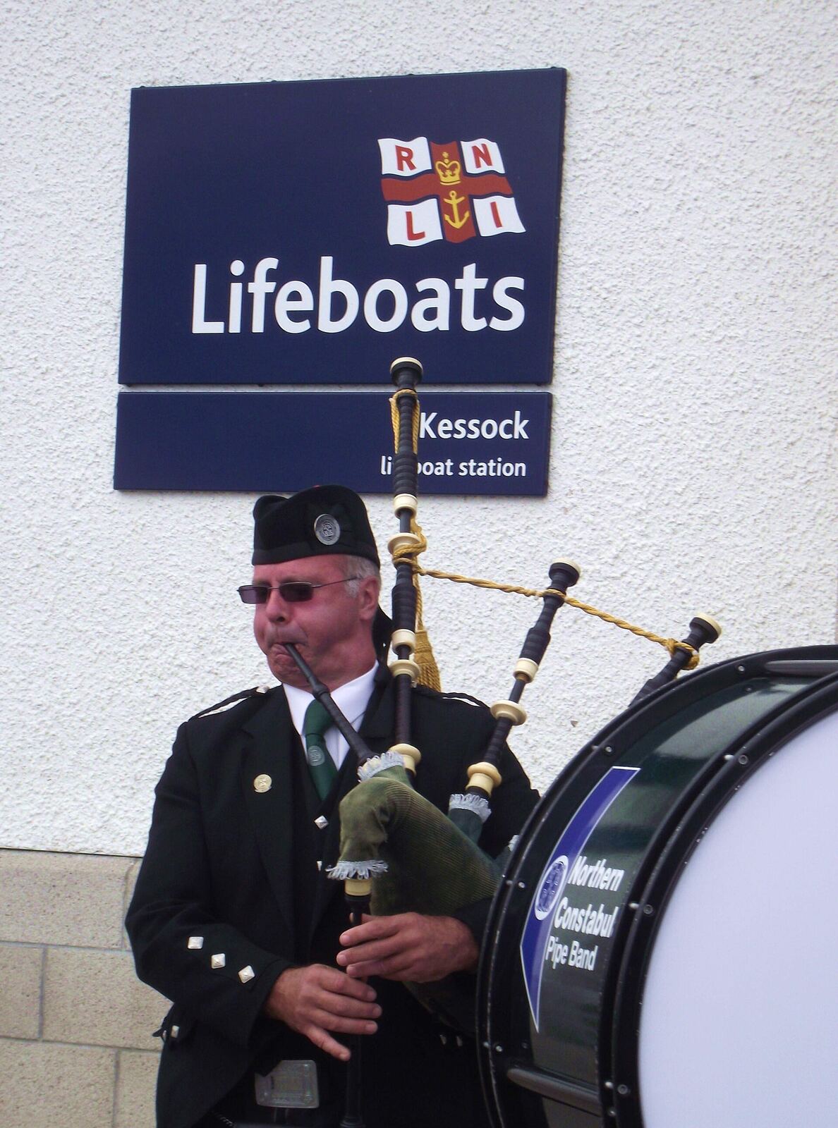 1,000 views on 24th October 2013 Pipe Major Kenny Watson leading the band - between the RNLI logo and the Pipe Band one! The village of Kessock (a.k.a. North Kessock) lies directly across the Beauly Firth from the City of Inverness. Until fairly recently, a ferry ran between the two, but since 1982 the imposing Kessock Bridge (carrying the A9 trunk road north from Inverness) has joined the two communities. en.wikipedia.org/wiki/Kessock_Bridge Kessock lies directly opposite the mouth of the River Ness, and Inverness Harbour and Marina, and the entrance to the Caledonian Canal is close by too. As a busy arm of the North Sea/Moray firth., the Beauly Firth is an important maritime route, both for commercial and leisure traffic. It took a long time to get a lifeboat based in the Inverness area but now that we do have the facility, locals are extremely proud - and supportive - of the Kessock lifeboat and its brave crew. The Lifeboat station is located at Craigton Point, directly under the north end of the Kessock Bridge. Several Band members have family or friends in the crew, hence we were delighted to be able to support and assist at the RNLI Kessock Station open day today (24th August 2013) by providing a mini-band to entertain the visitors. Kessock is one of Scotland’s youngest lifeboat stations, operating an inshore B class Atlantic 75 lifeboat – “The Moray Dolphin”. For over 10 years the lifeboat crews have launched the lifeboats, not only to save lives at sea but also to save lives inland during flooding. rnli.org/findmynearest/station/Pages/Kessock-Lifeboat-Sta...